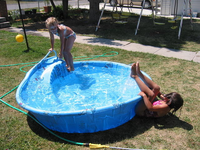 Carrie climbing onto the slide and Isabelle falling out of the pool.