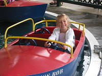 Carrie riding a boat ride at the amusement park.
