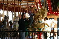 Aunt Michelle and Carrie wave to Uncle Shawn from the carousel.