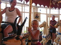 Krissy, Carrie, and Ric riding the carousel.